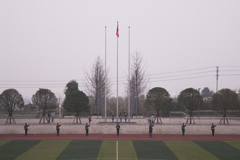 五星红旗冉冉升起,全体师生面向国旗行注目礼